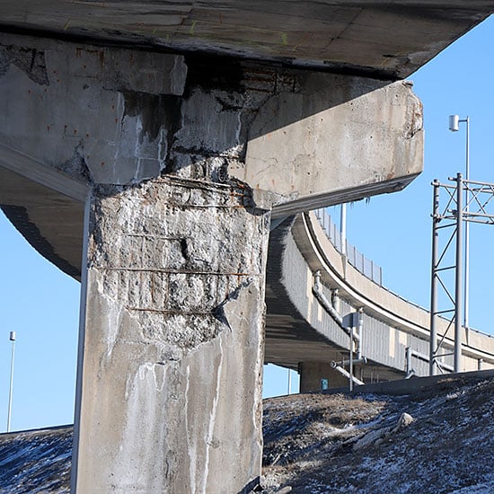 failing concrete on an overpass bridge support